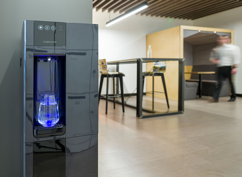 A B3 water dispenser positioned against a wall in a student working area