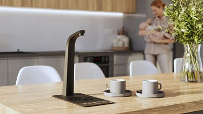 Example of a T3 hot tap on a wooden counter next to two cups of coffee