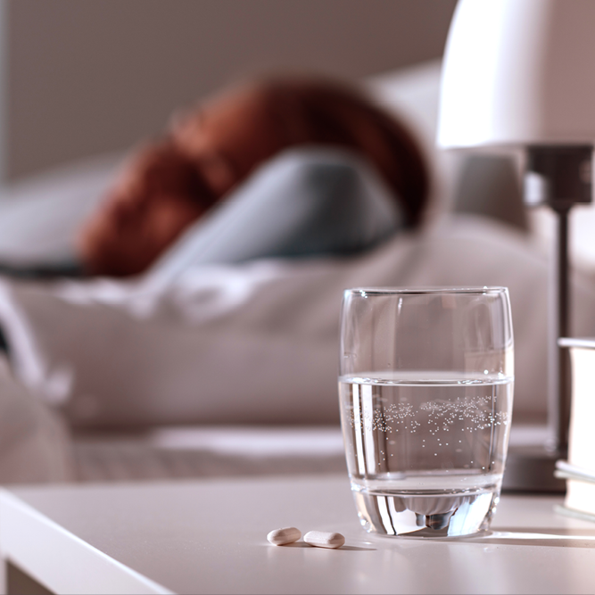 A clear glass of water placed on a night stand