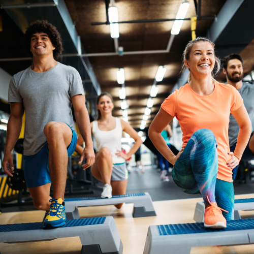 Diverse group of people participating in group fitness activities at the gym