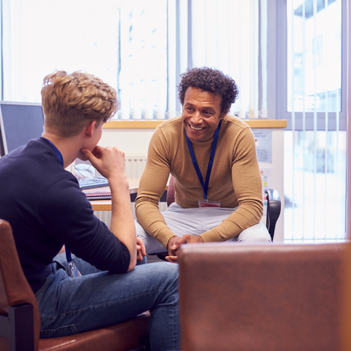 A workplace setting with a male therapist talking to a young man about mental health and well-being