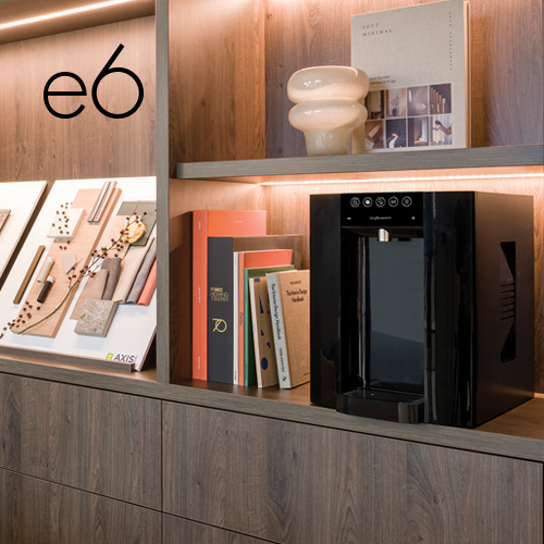 A Borg & Overström countertop E6, styled 'black', in a luxury office setting, positioned on a mahogany shelf.